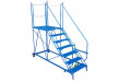 Blue mobile steel steps with large platform for loading and unloading lorries. 3 chains around the platform 