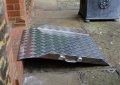 Aluminium wheelchair ramp resting on door step 
