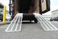 Pair of aluminium loading ramps resting on van