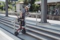 Folded rollator being lifted up steps 