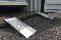 Pair of aluminium container ramps resting on container 
