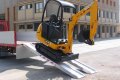 JCB Digger driving down pair of aluminium loading ramps 
