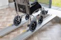 Wheelchair going up aluminium telescopic ramps