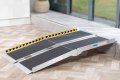 Antislip portable multifold wheelchair ramp resting on step 