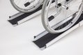 End of telescopic channel ramps with a manual wheelchair going up the access ramp 