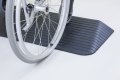 Wheelchair going up threshold ramp