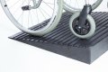 Manual wheelchair on a pair of rubber threshold ramps