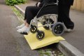 Wheelchair going down kerb using kerb ramp