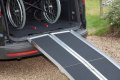 Multifold wheelchair ramp resting on car 