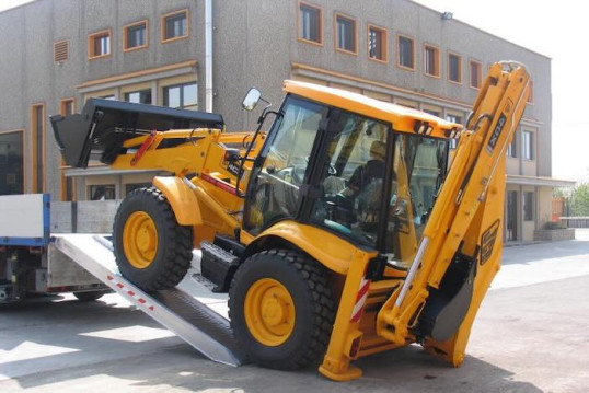 JCB driving up plant machinery loading ramps onto van