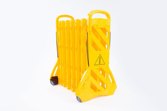 Yellow plastic expandable barrier on wheels