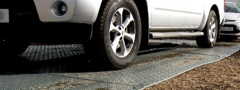 Car driving on ground protection mats