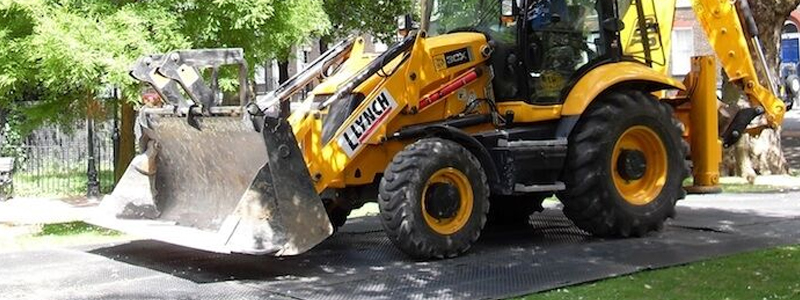 Digger driving on ground protection mats