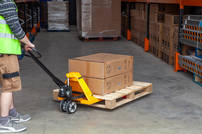 Warehouse team operating a manual pallet truck