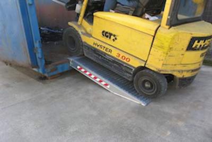 Forklift driving up pair of aluminium container ramps Forklift driving up pair of aluminium container ramps