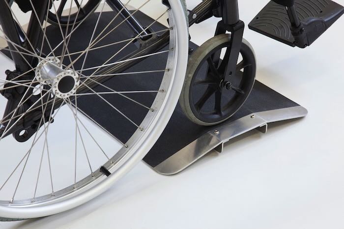 Wheelchair going up bridging ramp