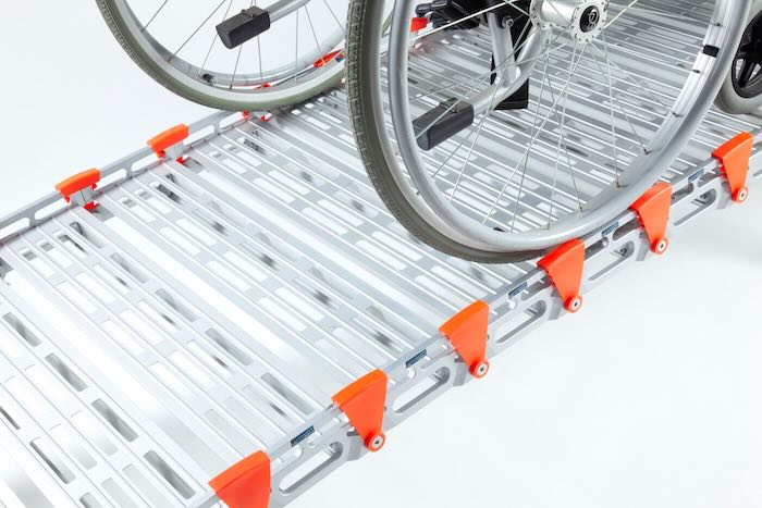 Wheelchair going up rollable ramp with safety edges