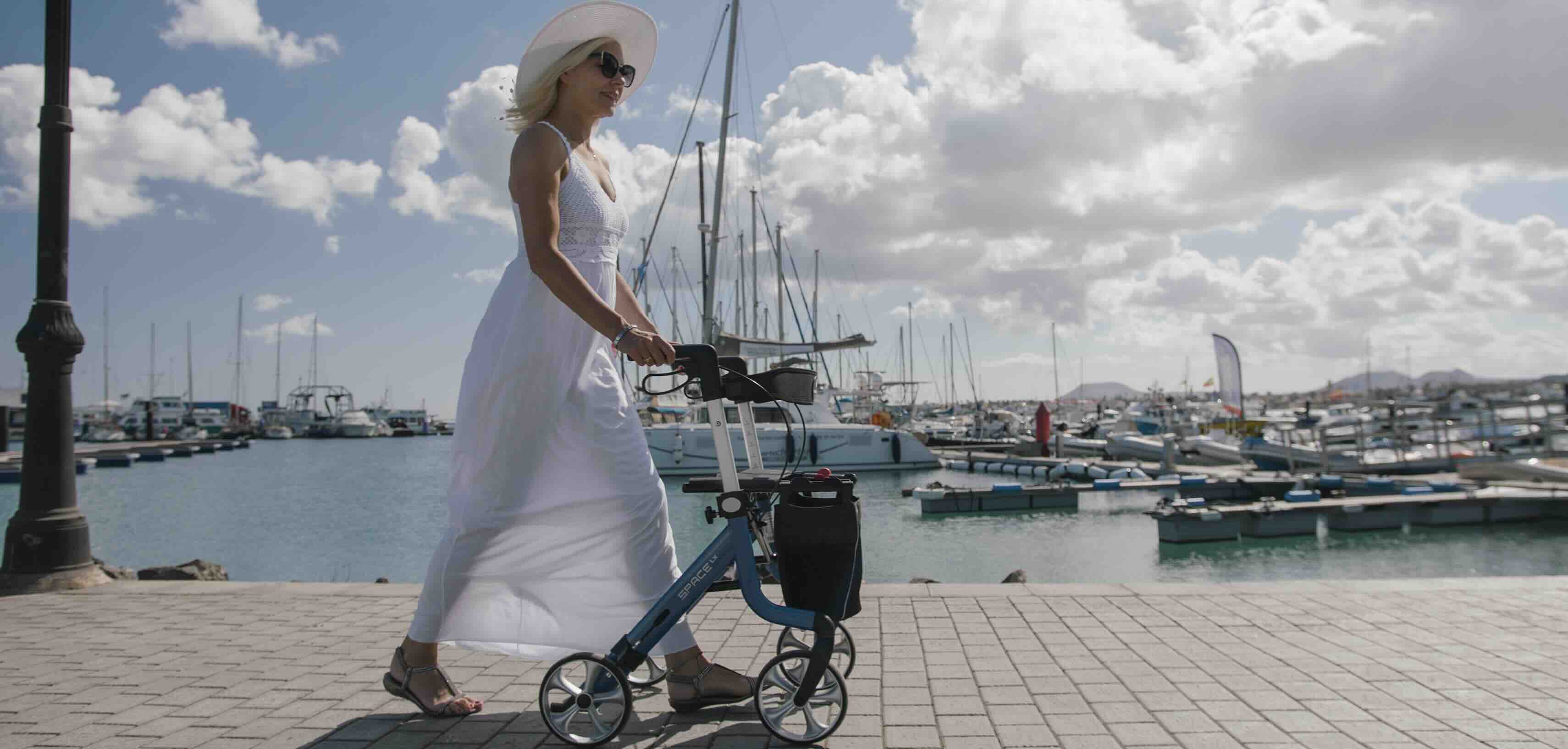 Lady walking with a blue Space LX rollator