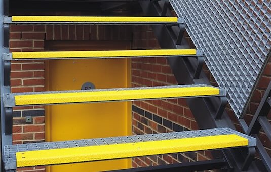 Yellow stair tread covers and nosing on metal steps 
