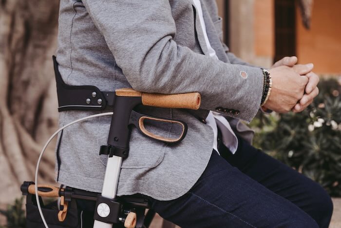 Man sat on rollator using armrests 