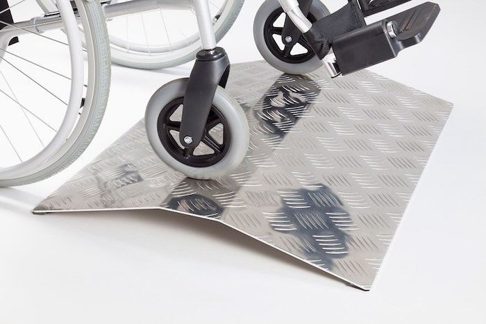 Wheelchair going over aluminium bridge ramp 
