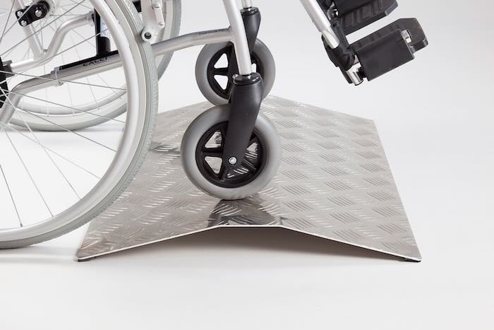 Wheelchair going over aluminium bridge ramp