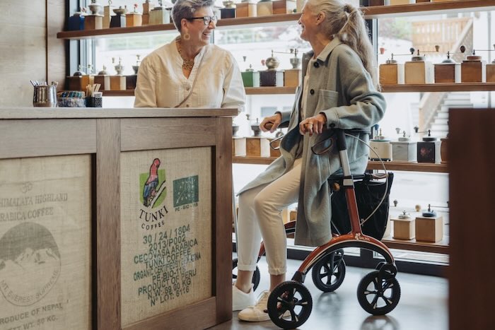 Lady sat on rollator in shop 