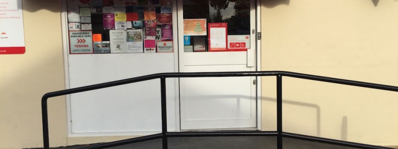Wheelchair ramp with handrails outside a shop