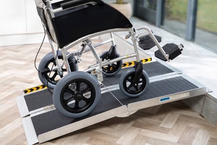 Wheelchair going up ramp onto step