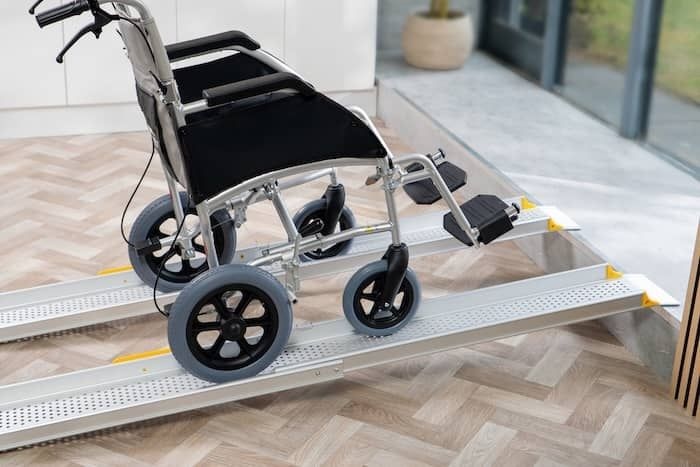 Manual wheelchair going up a pair of wheelchair ramps onto a step Manual wheelchair going up a pair of wheelchair ramps onto a step