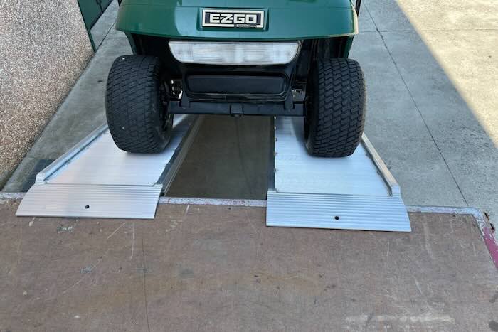 Aluminium ramps resting on flat bed vehicle 