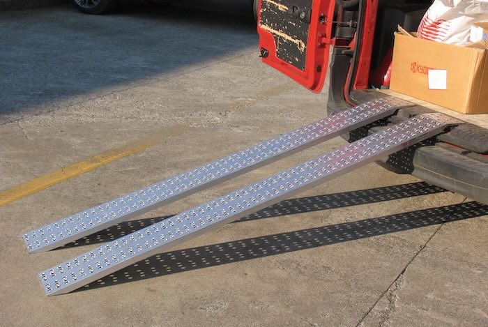 Lightweight aluminium loading ramps resting on van Lightweight aluminium loading ramps resting on van