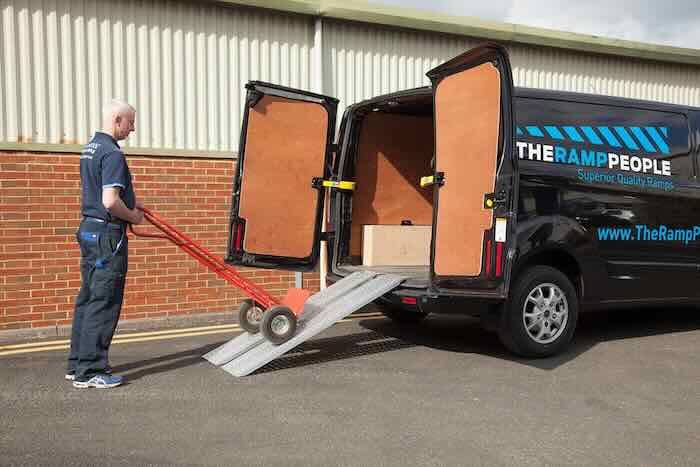 Man loading trolley up ramps Man loading trolley up ramps
