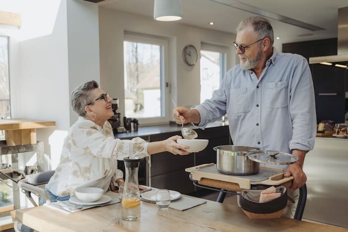 Two people in kitchen using saljol indoor rollator to serve food Two people in kitchen using saljol indoor rollator to serve food