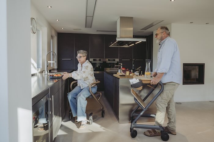 Two people using Saljol indoor rollator in kitchen