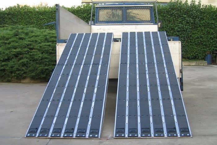 Heavy duty loading ramps for steel tracked machinery resting on a van