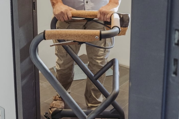 Indoor rollator Man pushing Indoor rollator through doorway