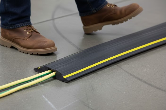 Person stepping over floor cable protector