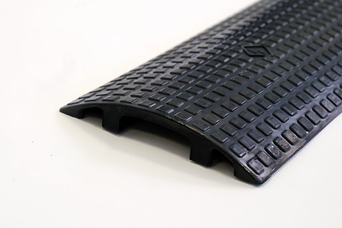 Floor cable protector with cable passing through 