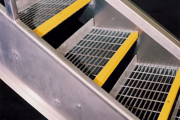 Yellow anti-slip stair nosing on metal staircases