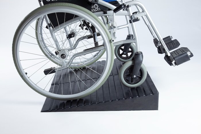 Wheelchair going up a pair of rubber ramps