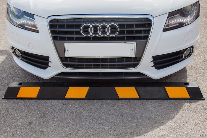 Car infront of rubber wheel stop on concrete 