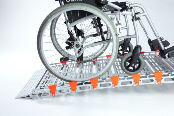 Manual wheelchair going up RollAble Access Ramp