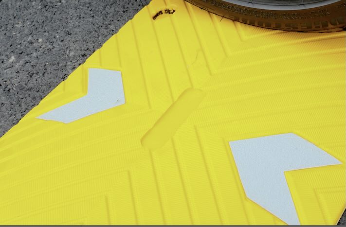 Yellow section of the speed bump with reflective chevrons 