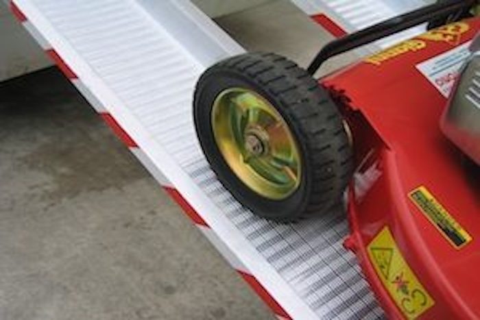 Lawnmower going up pair of aluminium loading ramps 