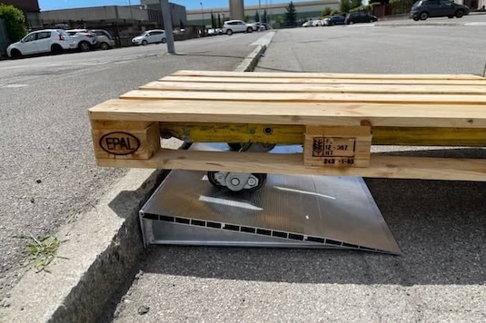 Pallet truck going up aluminium wedge ramp 